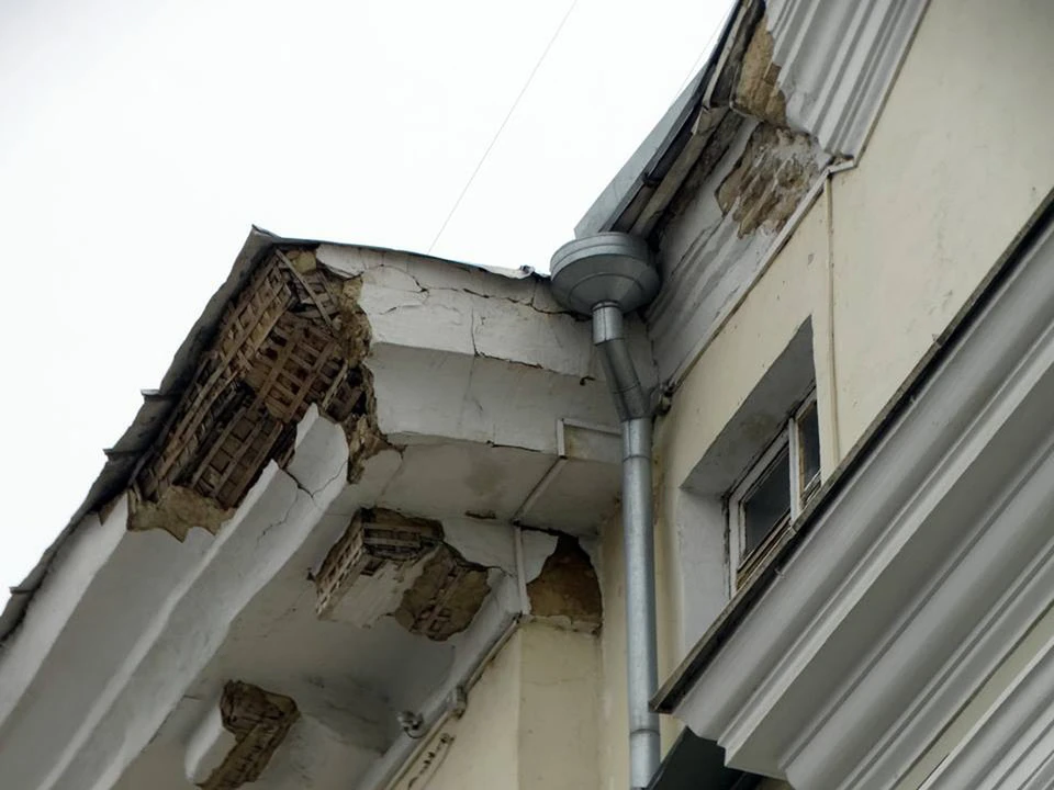 Под крышей дома, который носит статус памятника архитектуры, отваливаются куски штукатурки. Фото: Юрий Латышев.