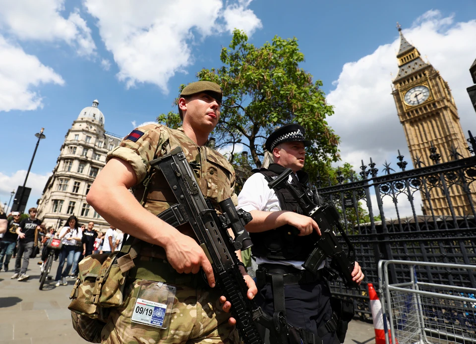 Полицейский и военнослужащий патрулируют центр Лондона.