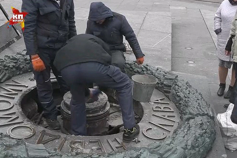 Киевские коммунальщики за очисткой Вечного огня от цемента.