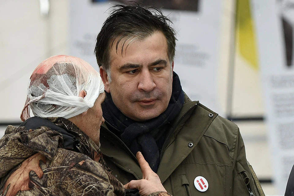Михаил Саакашвили общается со своим сторонником, пострадавшим в ходе разгона палаточного лагеря в центре Киева.