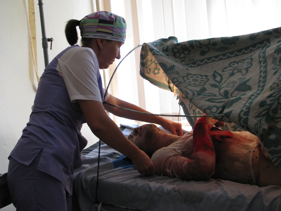 Палатная медсестра Надежда Белова оказывает медицинскую помощь обгоревшему макеевчанину Николаю Гончару