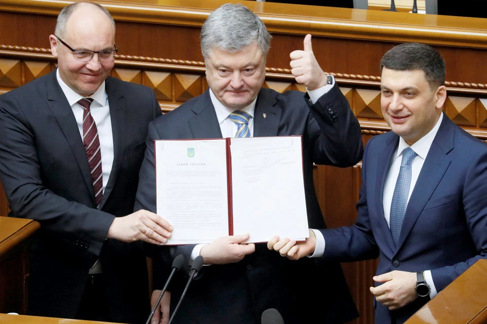 Спикер Рады Андрей Парубий, президент Петр Порошенко и премьер-министр Владимир Гройсман держат в руках утвержденный парламентом документ, которым на конституционном уровне закрепляется желание Украины вступить в НАТО и ЕС.