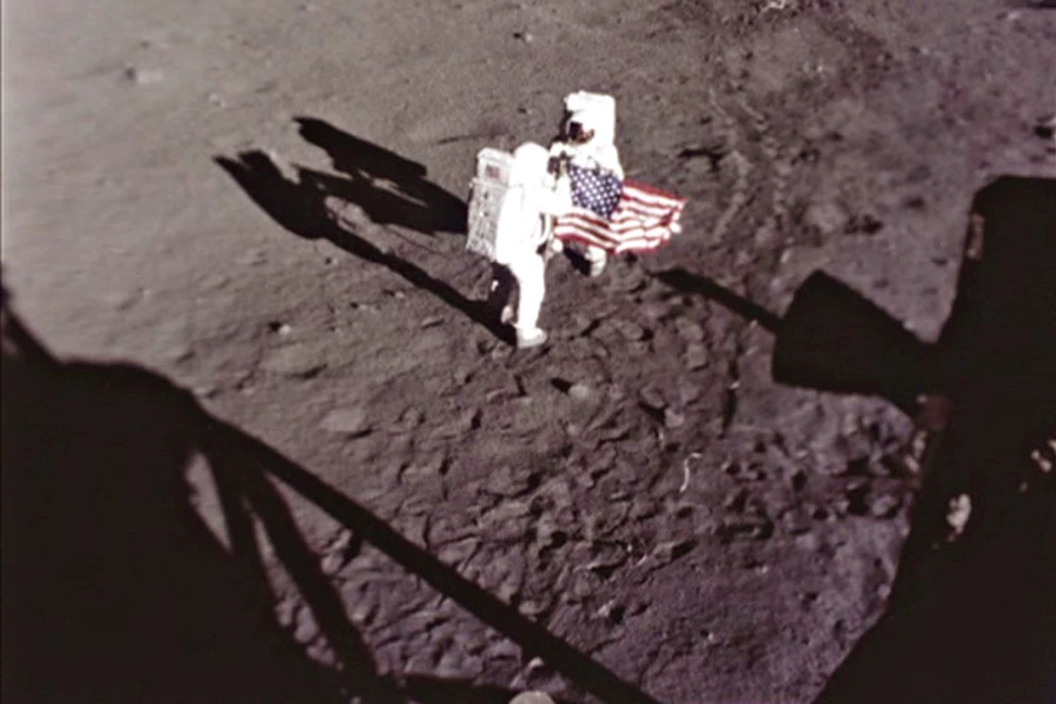 Армстронг и Олдрин устанавливают первый флаг на Луне. Снимает автоматическая камера с посадочного модуля.