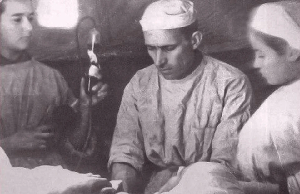 Операция в одном из эвакогоспиталей. Медсестра (справа) помогает хирургу, промакивая разрез ватным тампоном.