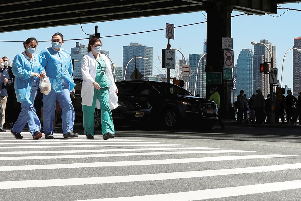 Врачи одной из клиник Нью-Йорка переходят улицу во время обеденного перерыва.