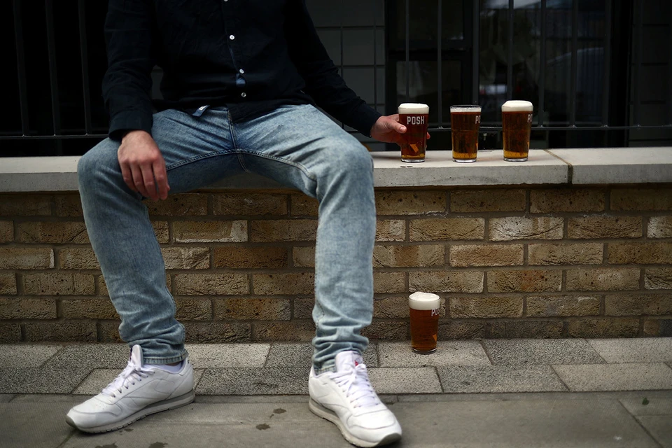 Британец с несколькими пинтами свежего пива, которые налили ему владельцы специального "паба на колесах", Лондон, май 2020 года.