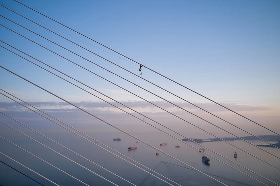 Альпинисты очищают ванты Русского моста от льда. Фото: Виктор Гохович