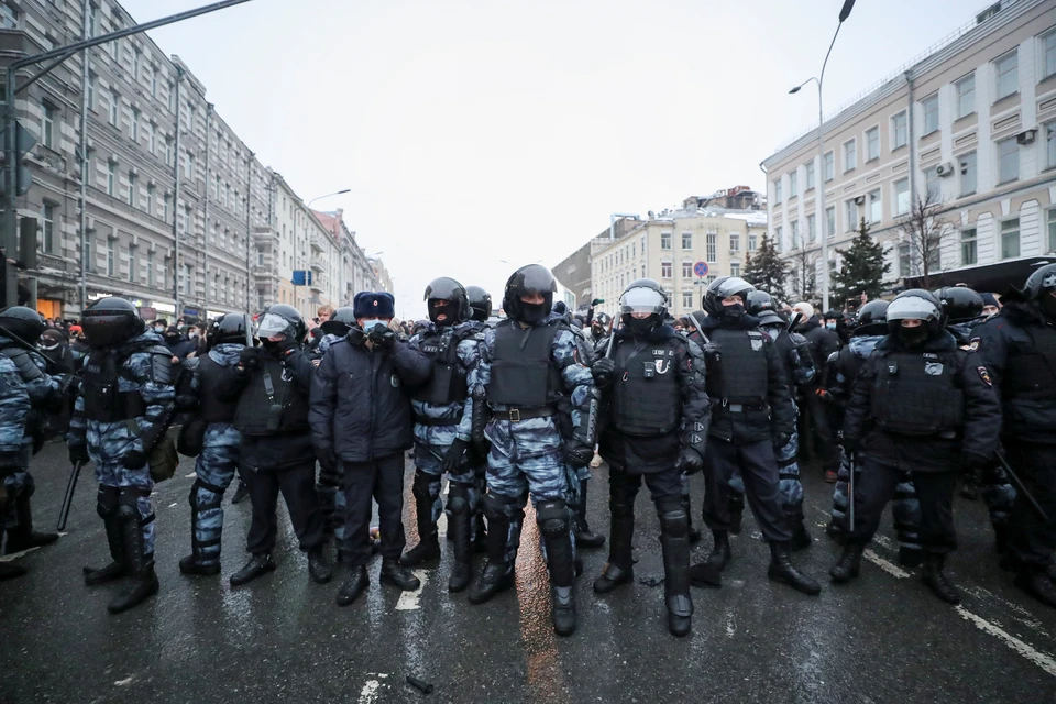 Толпу, вышедшую на проезжую часть, пытается остановить небольшая цепь ОМОНовцев