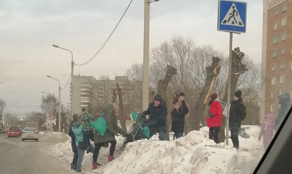 А пока жители прыгают через сугробы у пешеходных переходов.