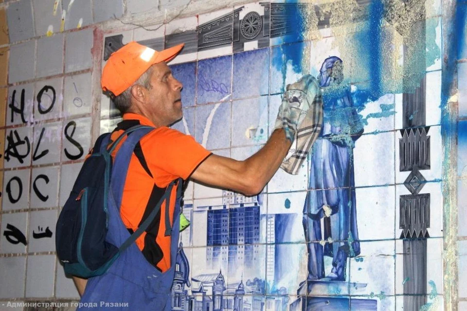 На фото рабочий ДБГ отчищает мозаику от краски. Фото: сайт горадминистрации.