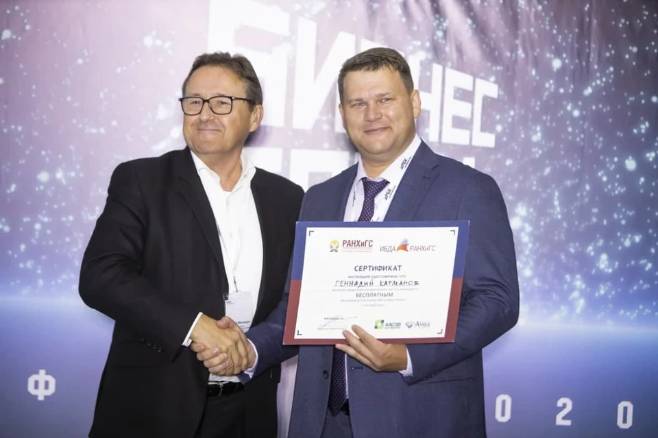 Директор ИБДА РАНХиГС Сергей Мясоедов вручает сертификат победителю «Бизнес Баттла» Геннадию Карманову.
