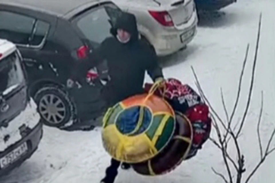 Мужчина ворует из подъезда тюбинги и лыжи Фото: facebook.com/maksim.zirkov (скрин видео)