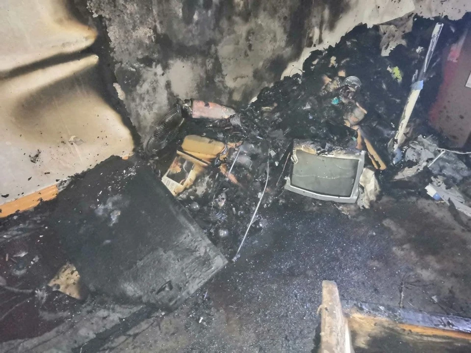 В результате возгорания в комнате обгорели телевизор и вещи, закоптились стены.