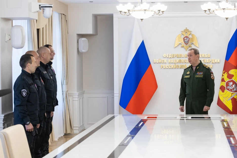 Виктор Золотов вручил военнослужащим боевые медали, а они передали в музей ведомства трофейные флаги националистических формирований Украины. Фото: Росгвардия РФ