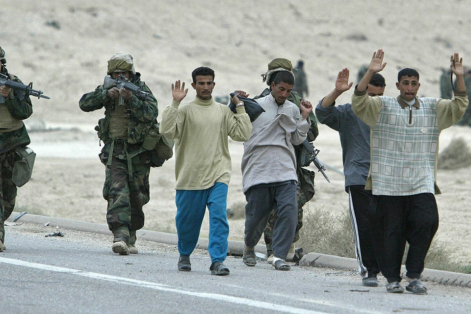 Март 2003 года, американские морпехи держат на прицеле группу иракских солдат, одетых в гражданское.
