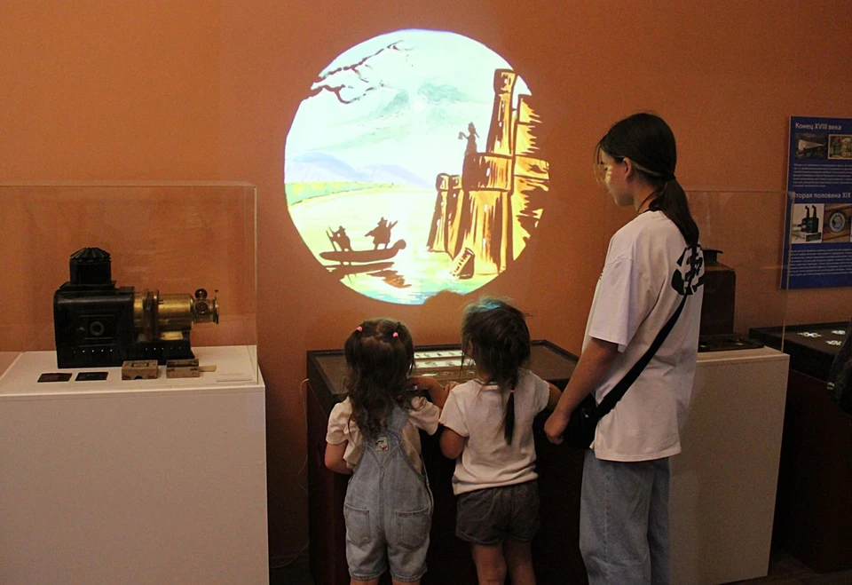 Посетители с интересом наблюдают за анимационной проекцией на стене