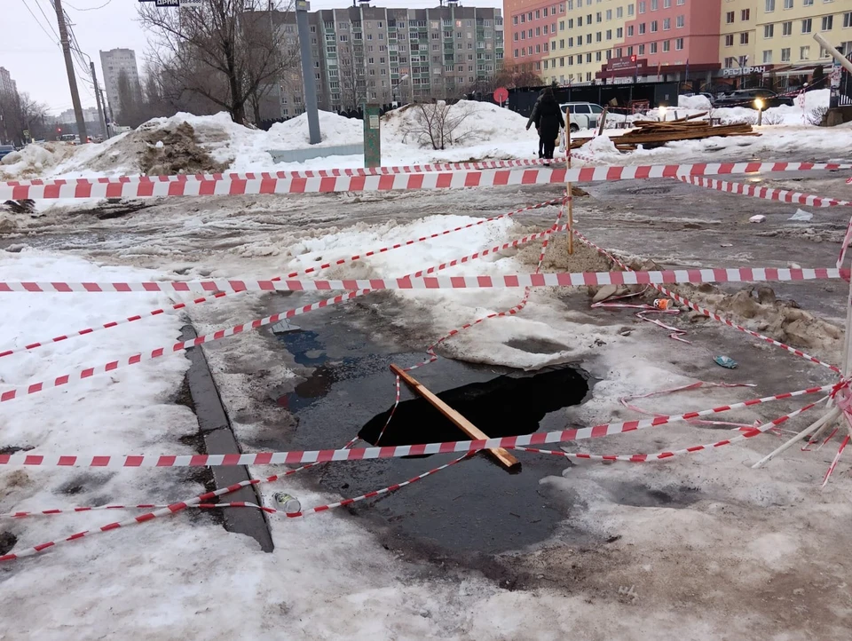 Дыру в асфальте огородили сигнальными лентами.