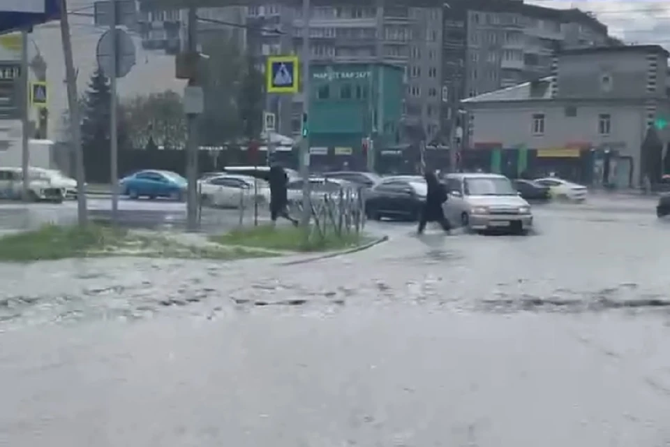Новосибирцы переходят Ипподромскую магистраль по колено в воде. Фото: читатель КП