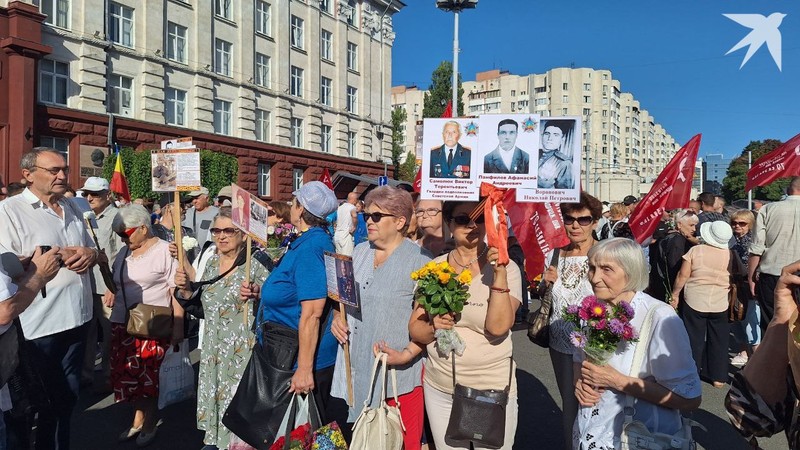 В руках у участников марша - фото героев и цветы.