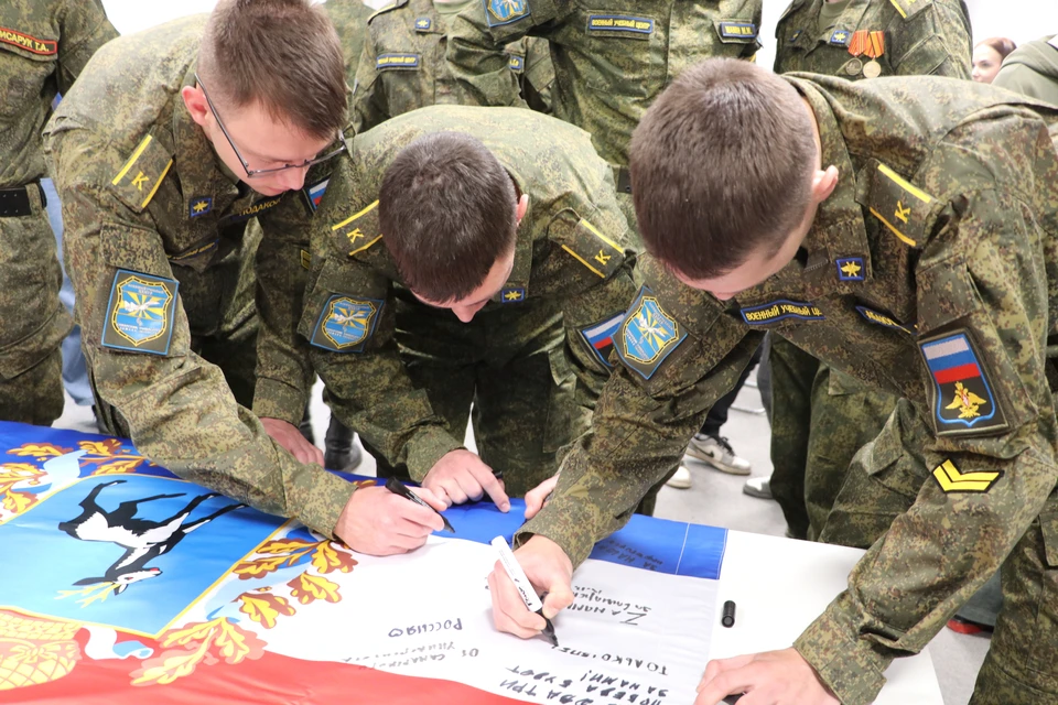 Участники мероприятия написали на флаге слова поддержки и благодарности героическим землякам. Фото: самарское реготделение партии "Единая Россия"