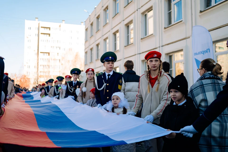 Принятые в движение первоклассники с помощью кадетов и юнармейцев растянули перед зданием лицея стометровый флаг России.