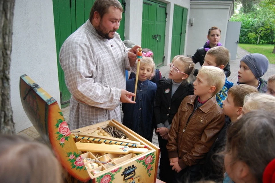 На фото Пушкинского Заповедника: сотрудник музея Сергей Ешин рассказывает белорусским ребятишкам, в какие игры играли псковские деревенские дети при Пушкине.