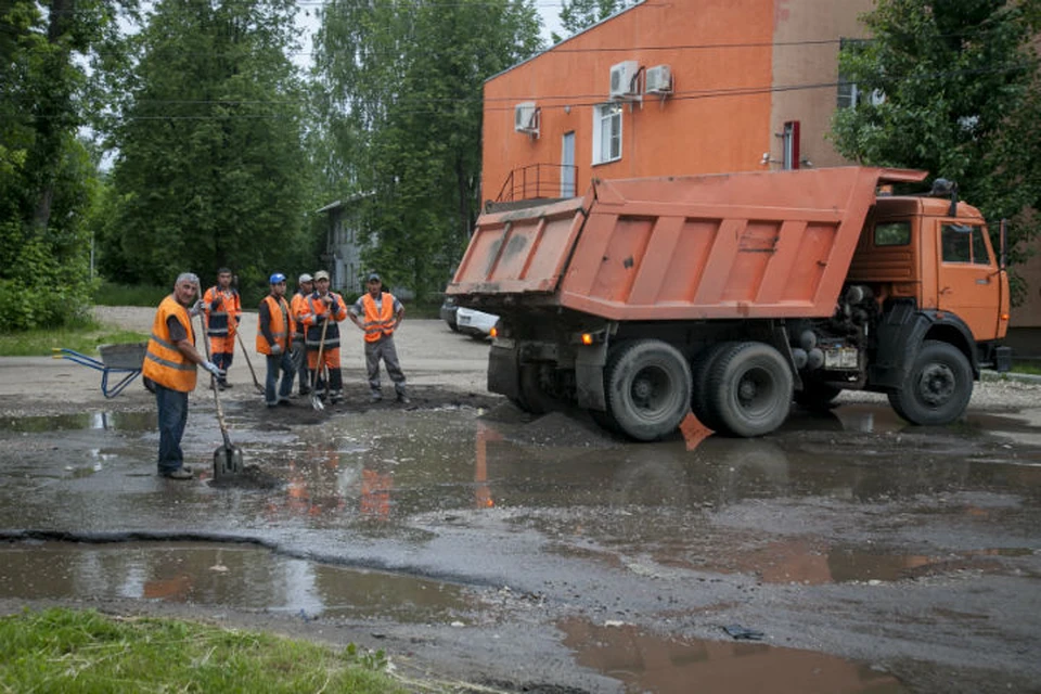 Рабочие положили асфальтовую крошку прямо в лужу.