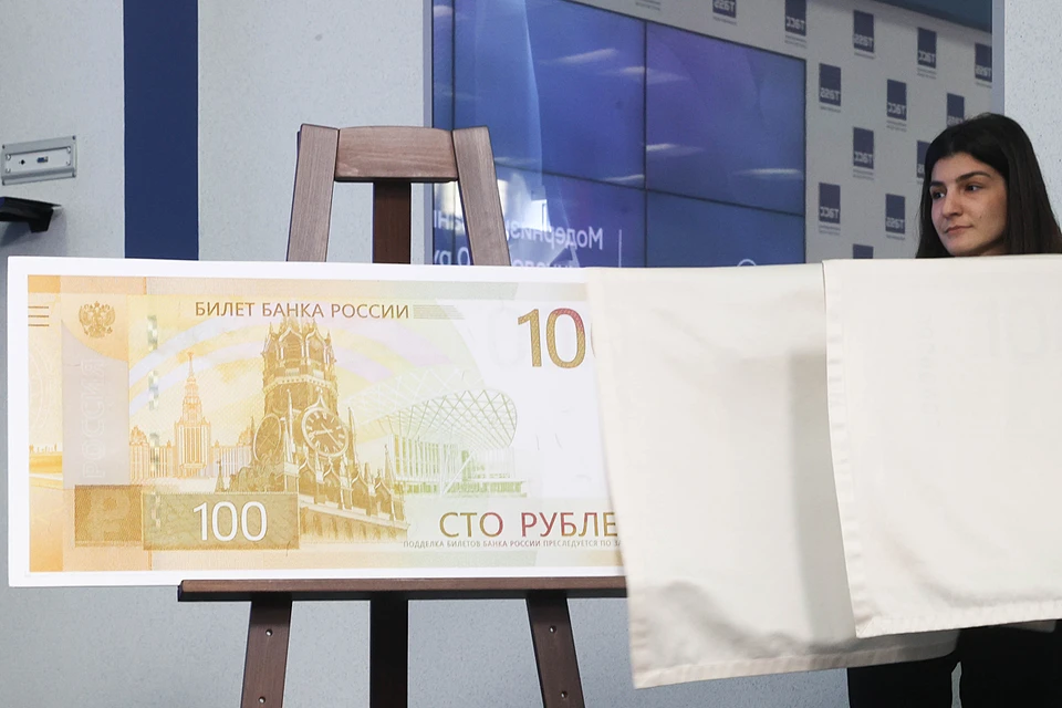 Банк России представил новую купюру в 100 рублей. На лицевой стороне изображён фрагмент Спасской башни Кремля, на обратной — Ржевский мемориал. Купюра вводится в обращение с сегодняшнего дня. Фото: Владимир Гердо/ТАСС